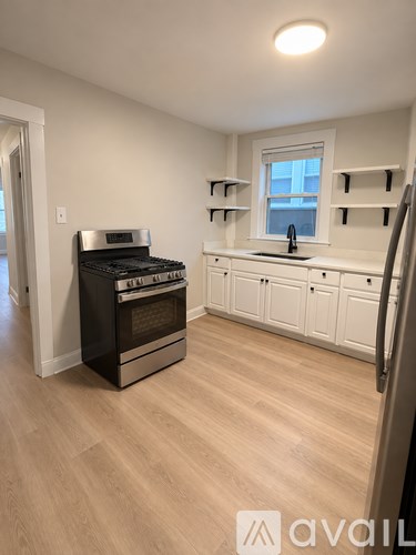 A kitchen with a black oven and white cabinets.