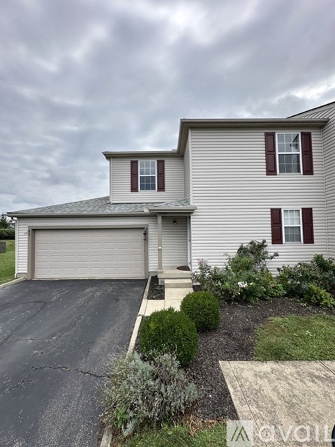 A two-story house with a garage and a driveway.