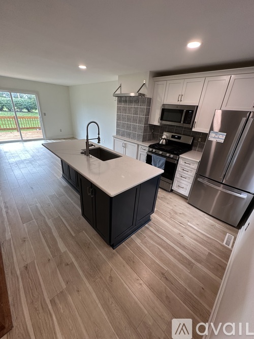 A kitchen with a sink, stove, and refrigerator.
