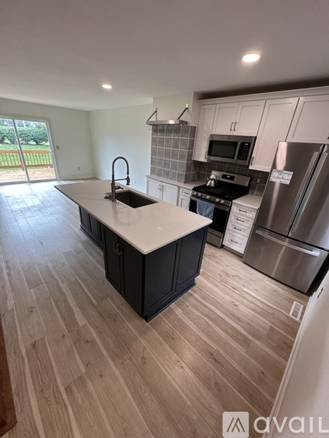 A kitchen with a sink, stove, and refrigerator.