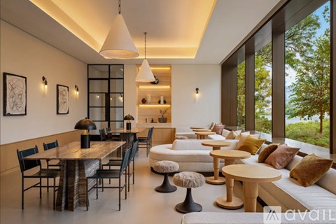 A modern dining room with a long table and chairs.