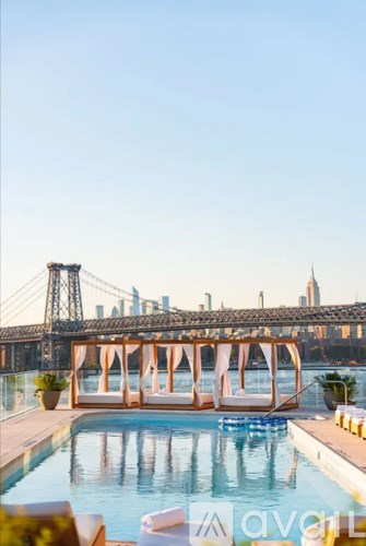 A pool with a view of a bridge and buildings in the background.