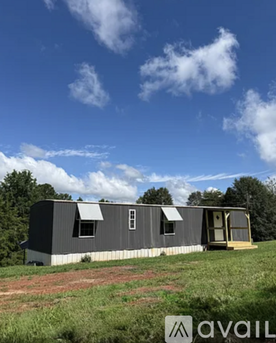 A grey house with a white roof is available for rent.