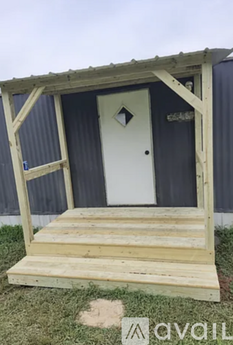 A wooden structure with a door and a step.
