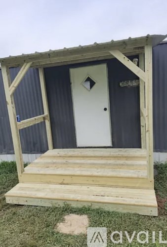 A wooden structure with a door and a step.