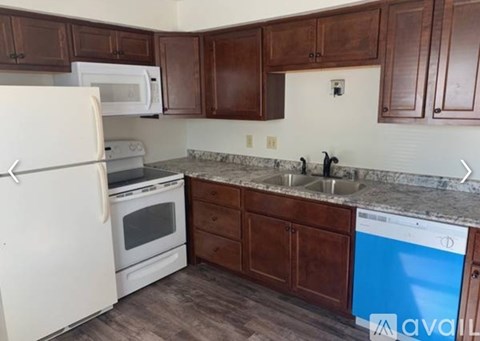 A kitchen with brown cabinets and a white fridge.