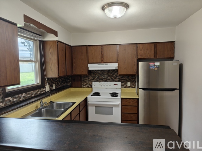 A kitchen with a white stove top oven and a black counter top.