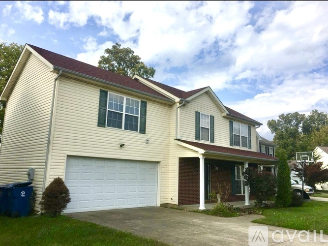 A two-story house with a garage and a driveway.