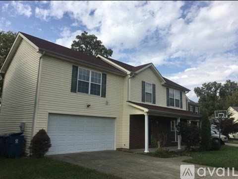 A two-story house with a garage and a driveway.