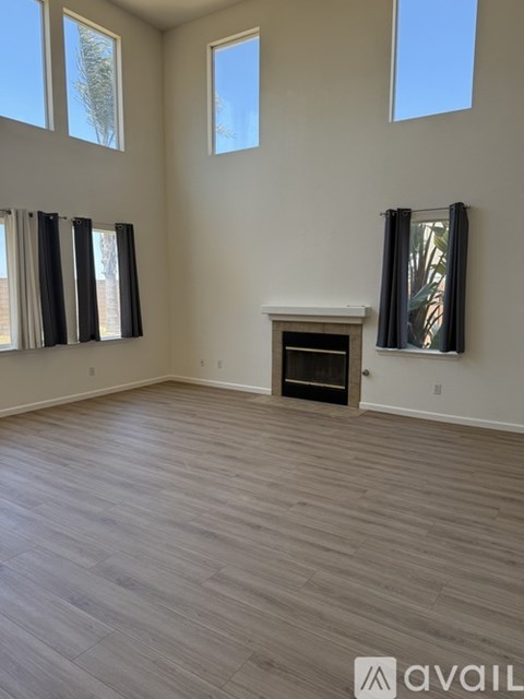A room with a fireplace and large windows.