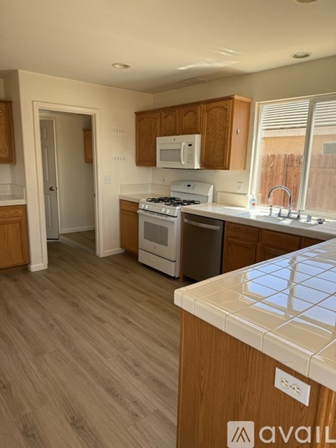 A kitchen with wooden cabinets and a white counter top.