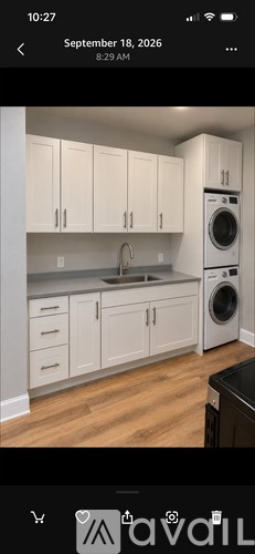 A modern kitchen with white cabinets and a black dishwasher.