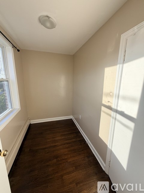 A room with a window and wooden flooring.