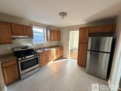 A kitchen with wooden cabinets and a stainless steel refrigerator.