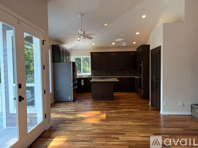 A modern kitchen with dark wood cabinets and a center island.