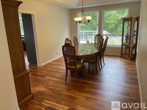 A dining room with a wooden table and chairs.