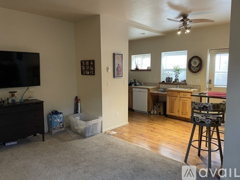 A living room with a television, a chair, and a fan.