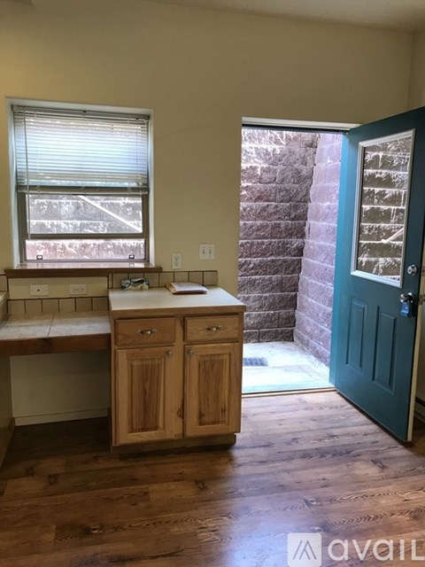 A kitchen with wooden cabinets and a window.