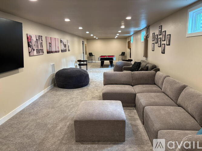 A living room with a grey sofa set and a black bean bag chair.