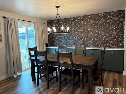 A dining room with a table and chairs.