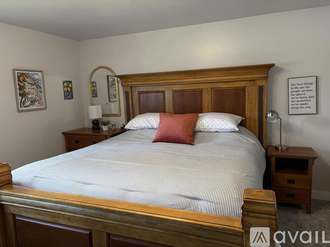 A bedroom with a large bed and a wooden headboard.