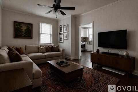 A living room with a couch, a coffee table, and a television.