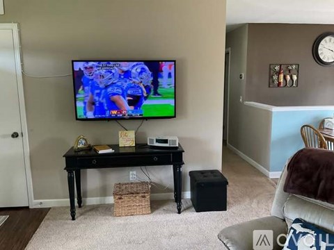 A living room with a television playing a football game.