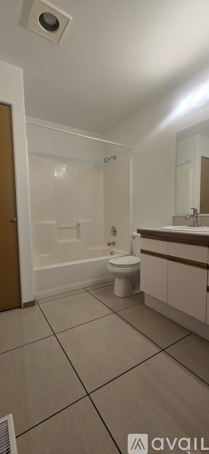 A bathroom with a toilet, sink, and mirror.