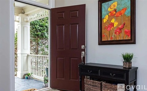 A brown door is open to a balcony with a white railing.