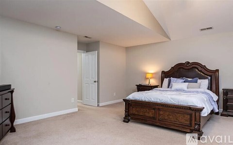 A bedroom with a large bed and a dresser.