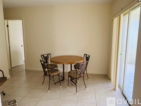 A dining room with a round table and four chairs.