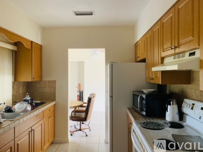 A kitchen with wooden cabinets and a white stove top oven.