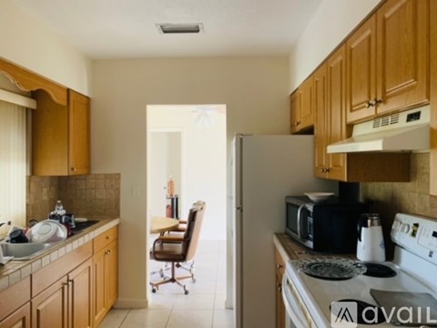 A kitchen with wooden cabinets and a white stove top oven.