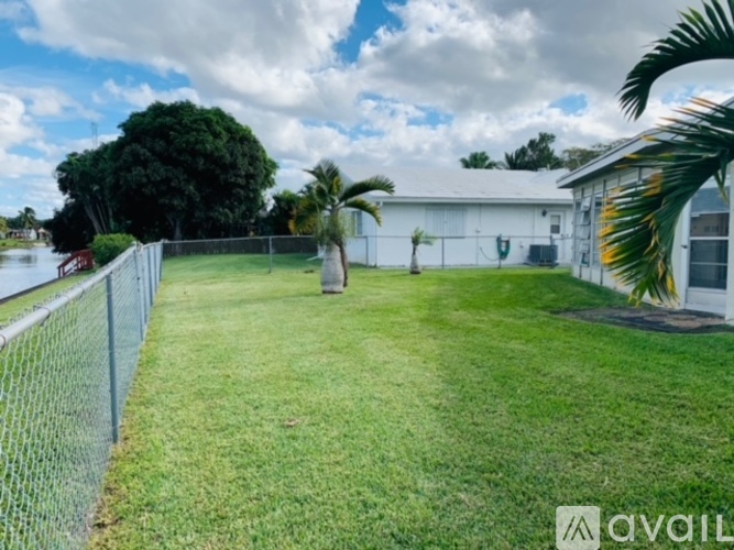 A white building with a green lawn in front of it.