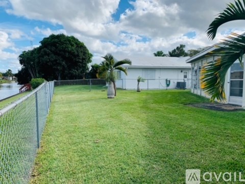 A white building with a green lawn in front of it.