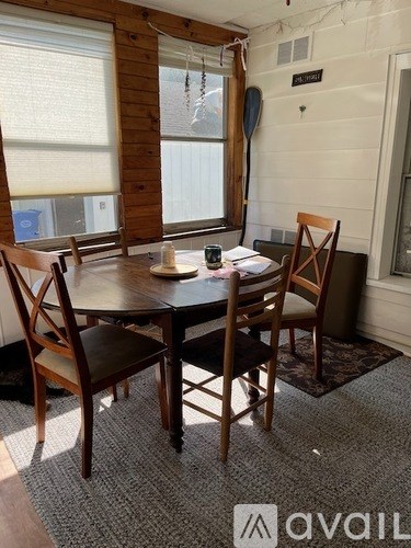 A dining room with a table and chairs.