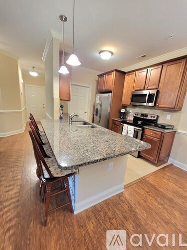 A kitchen with granite countertops and wooden cabinets.