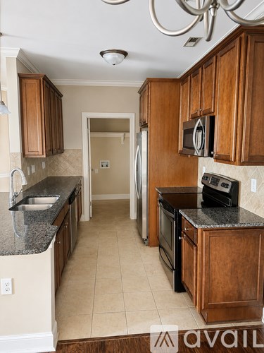 A kitchen with wooden cabinets and black countertops.