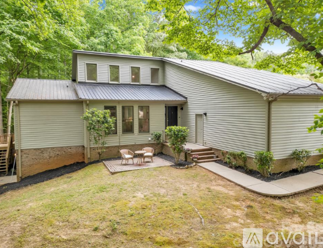 A house with a patio surrounded by trees.