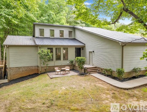 A house with a patio surrounded by trees.