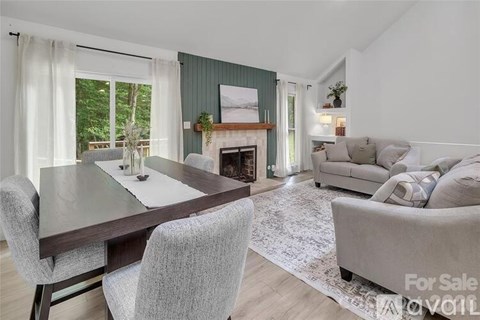 A living room with a fireplace and a dining table.