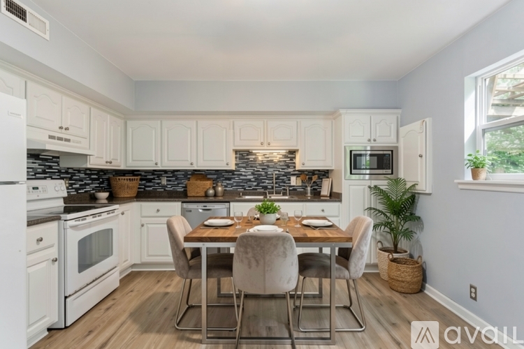 A kitchen with a table and chairs in the middle of the room.