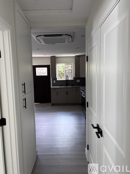 A hallway with white doors and a tiled floor.