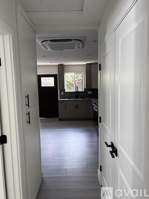 A hallway with white doors and a tiled floor.