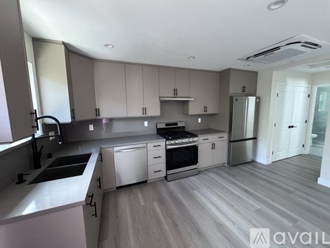 A modern kitchen with a sink, stove, and refrigerator.