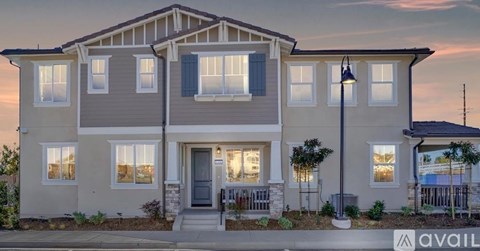 A modern two-story house with a front porch and a garage.