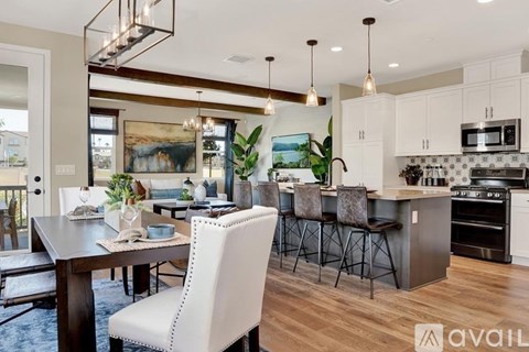 A modern kitchen with a dining table and chairs.