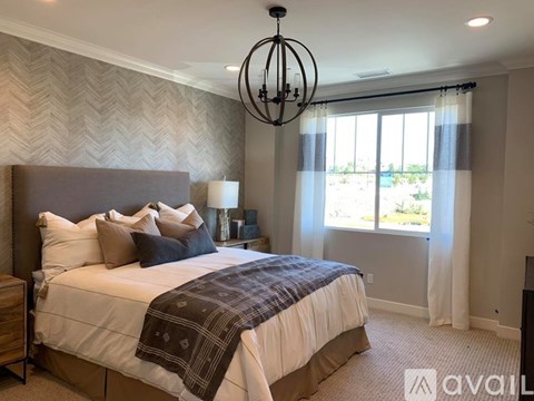 A bedroom with a large bed and a chandelier.