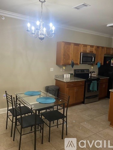 A kitchen with a table and chairs in front of it.