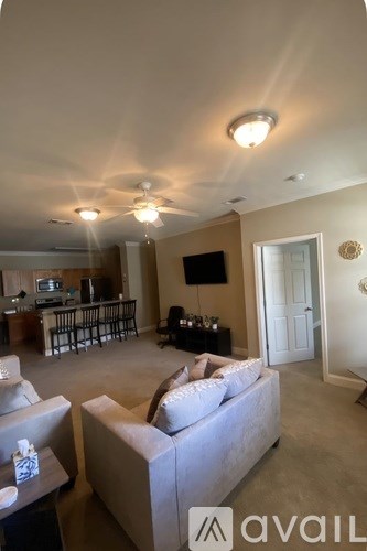 A living room with a couch, a coffee table, and a television.